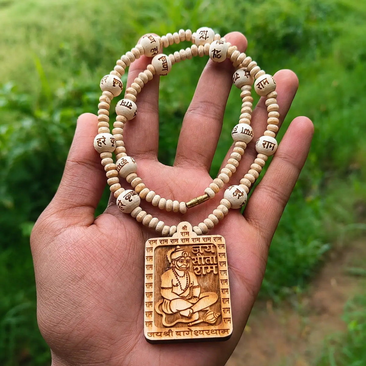 Tulsi mala held in hand showing engraved beads, part of the Bhakti Set