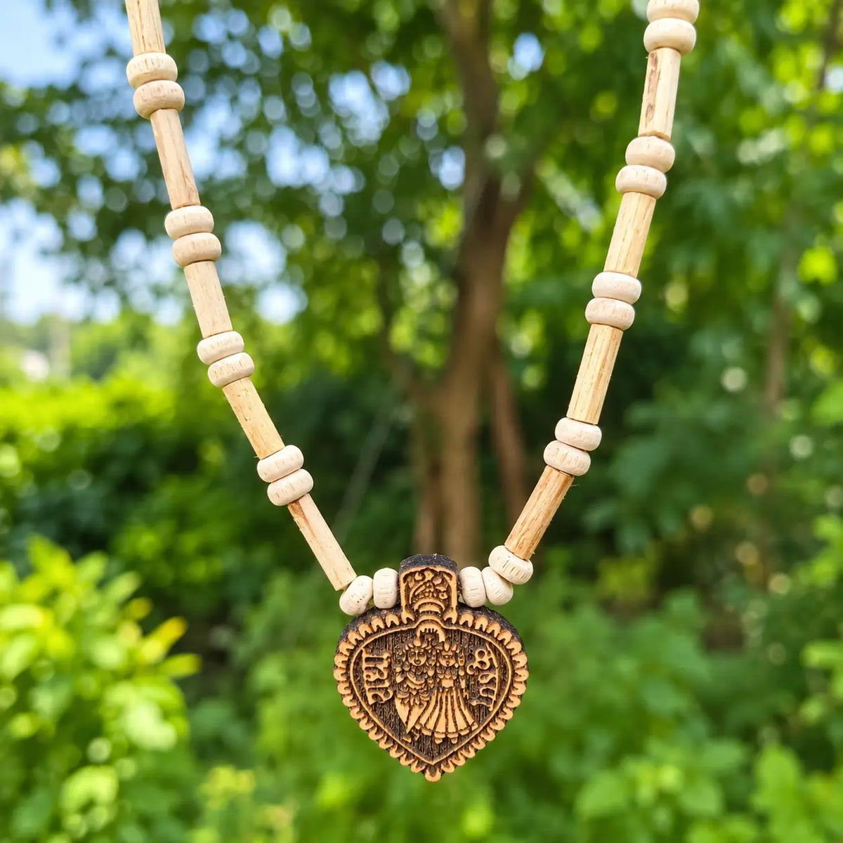 Close-up of engraved Radha Krishna pendant on Tulsi wood beads