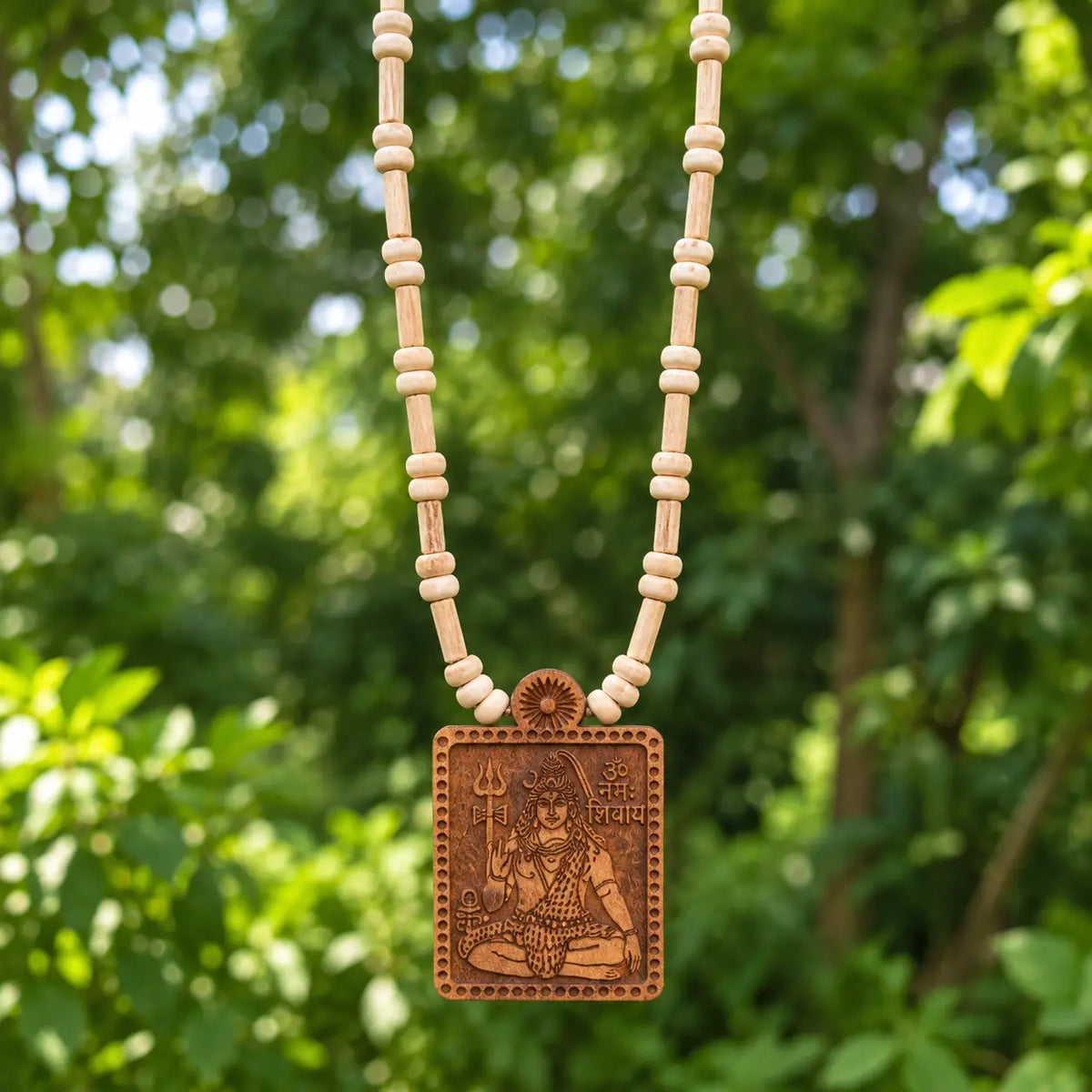 Close-up of engraved Mahadev pendant on Tulsi wood beads